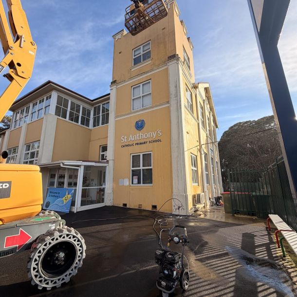 Pressure washing the original yellow facade of a Sydney primary school before painting