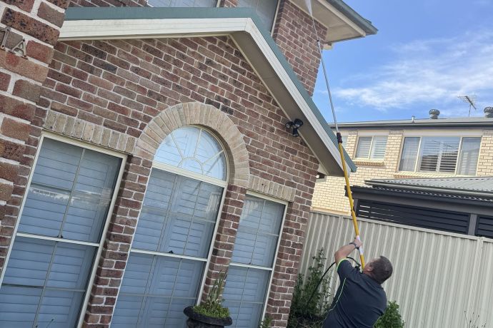 Pressure washing the front of a brick home
